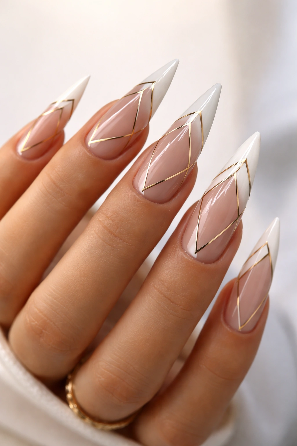 Stiletto nails with geometric white tips and metallic lines