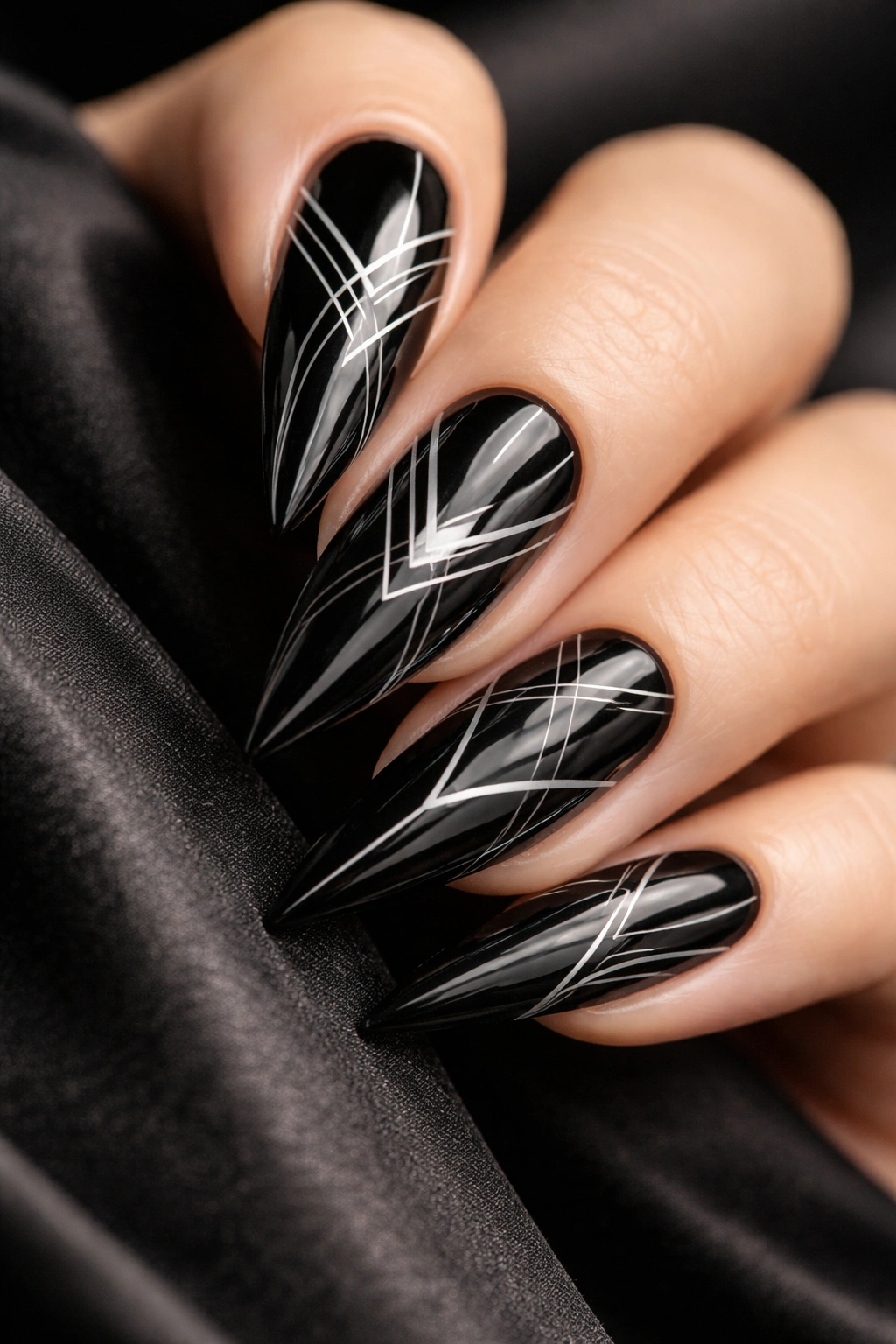 Close-up of black stiletto nails with geometric line art
