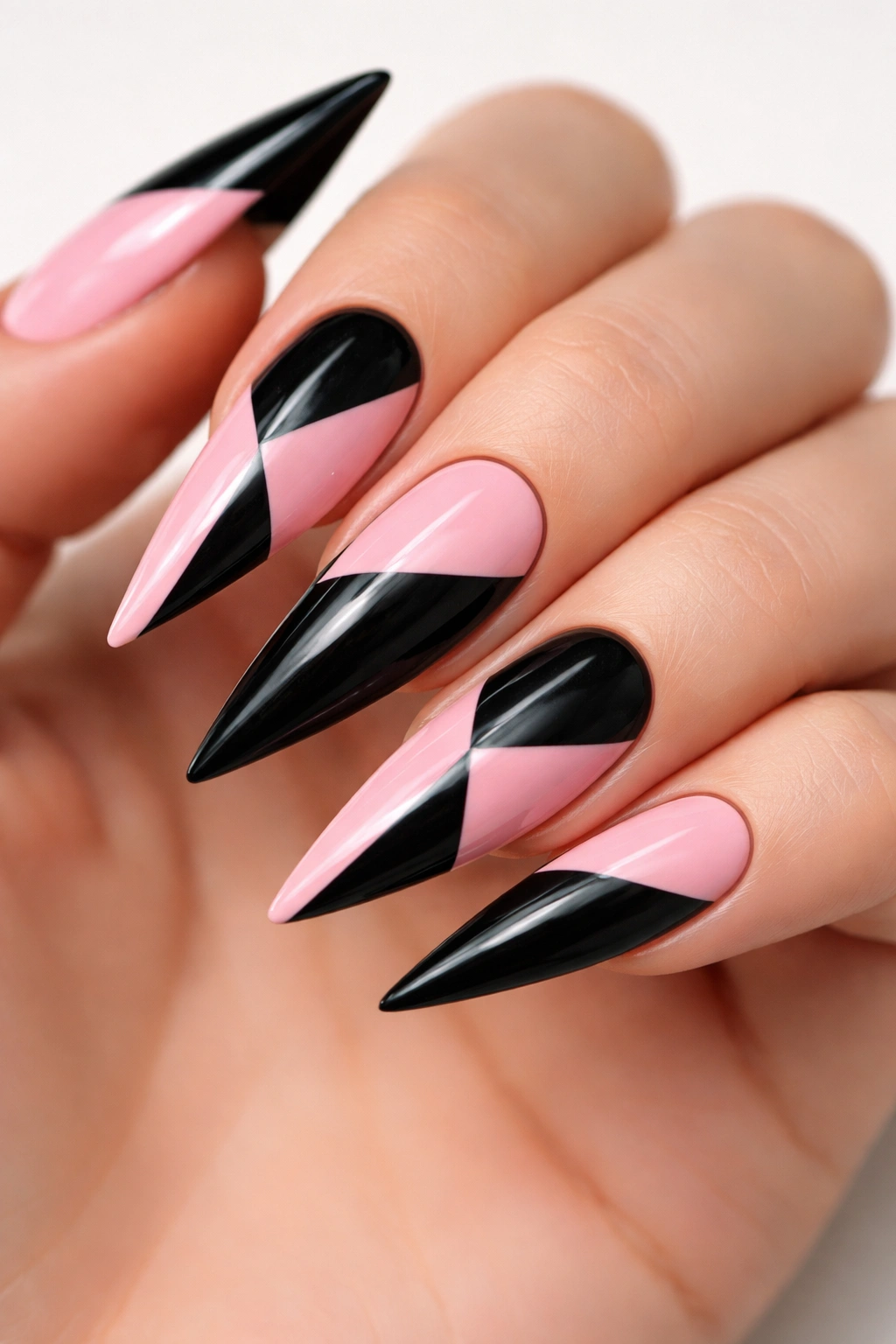 Geometric black and pink blocked nails on a hand