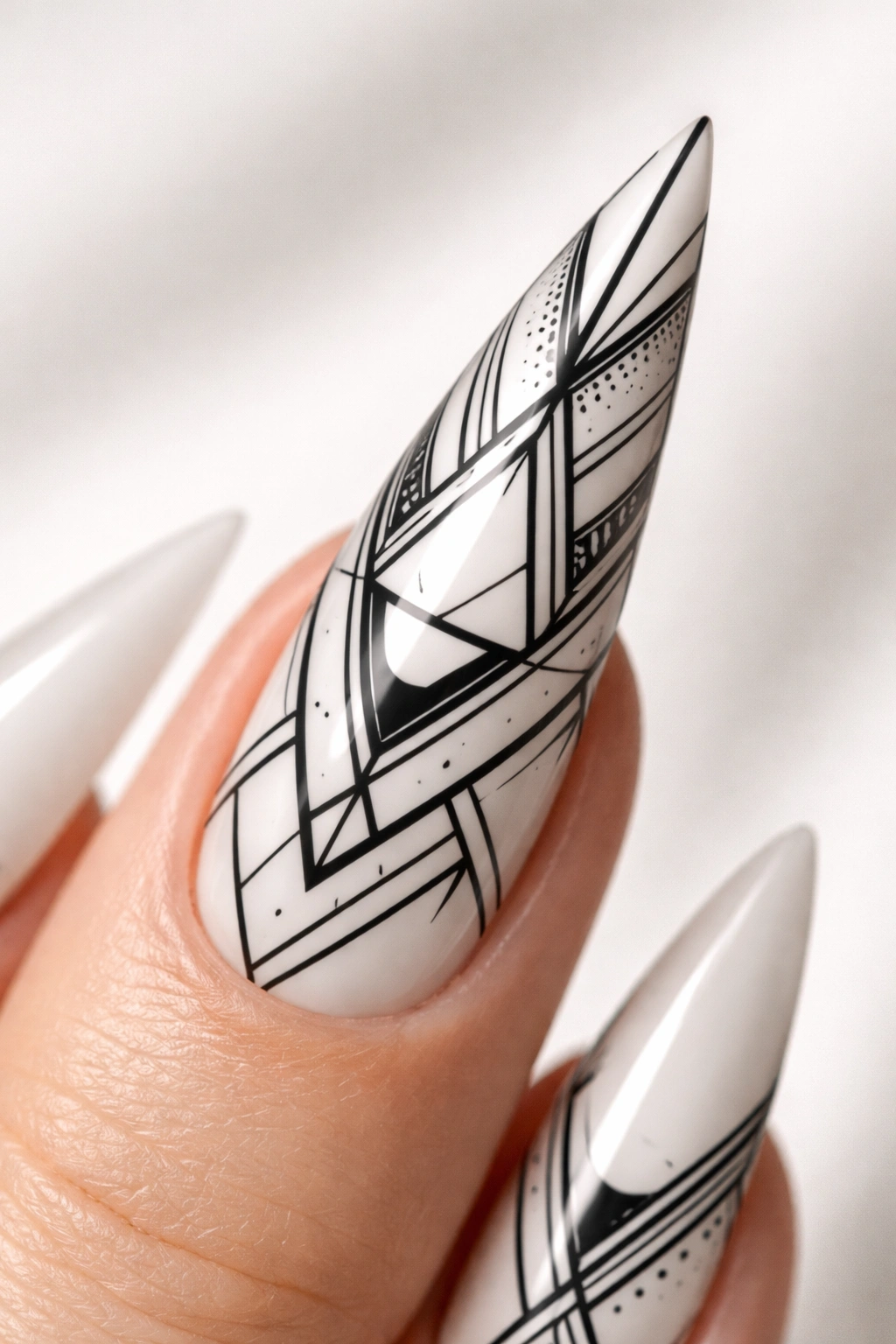 Stiletto nail with black geometric line art on white base