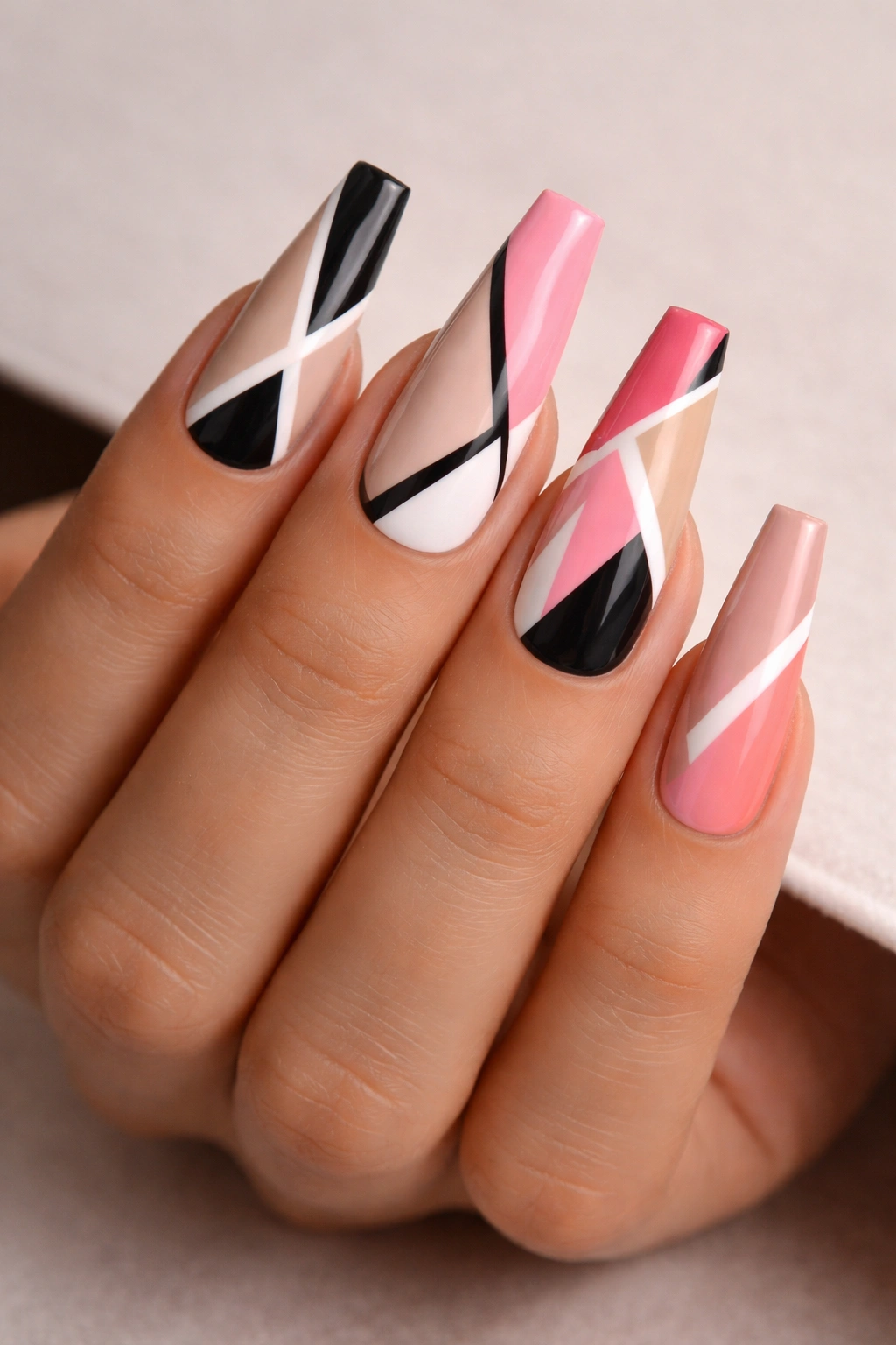 Close-up of geometric-pattern coffin nails on a bare hand