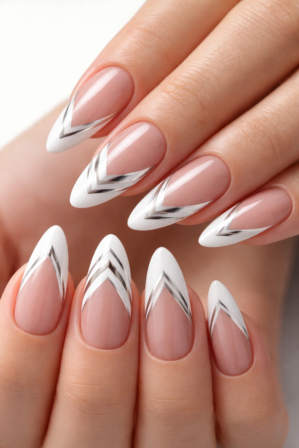 Nails with geometric French tips featuring sharp lines and chevron patterns