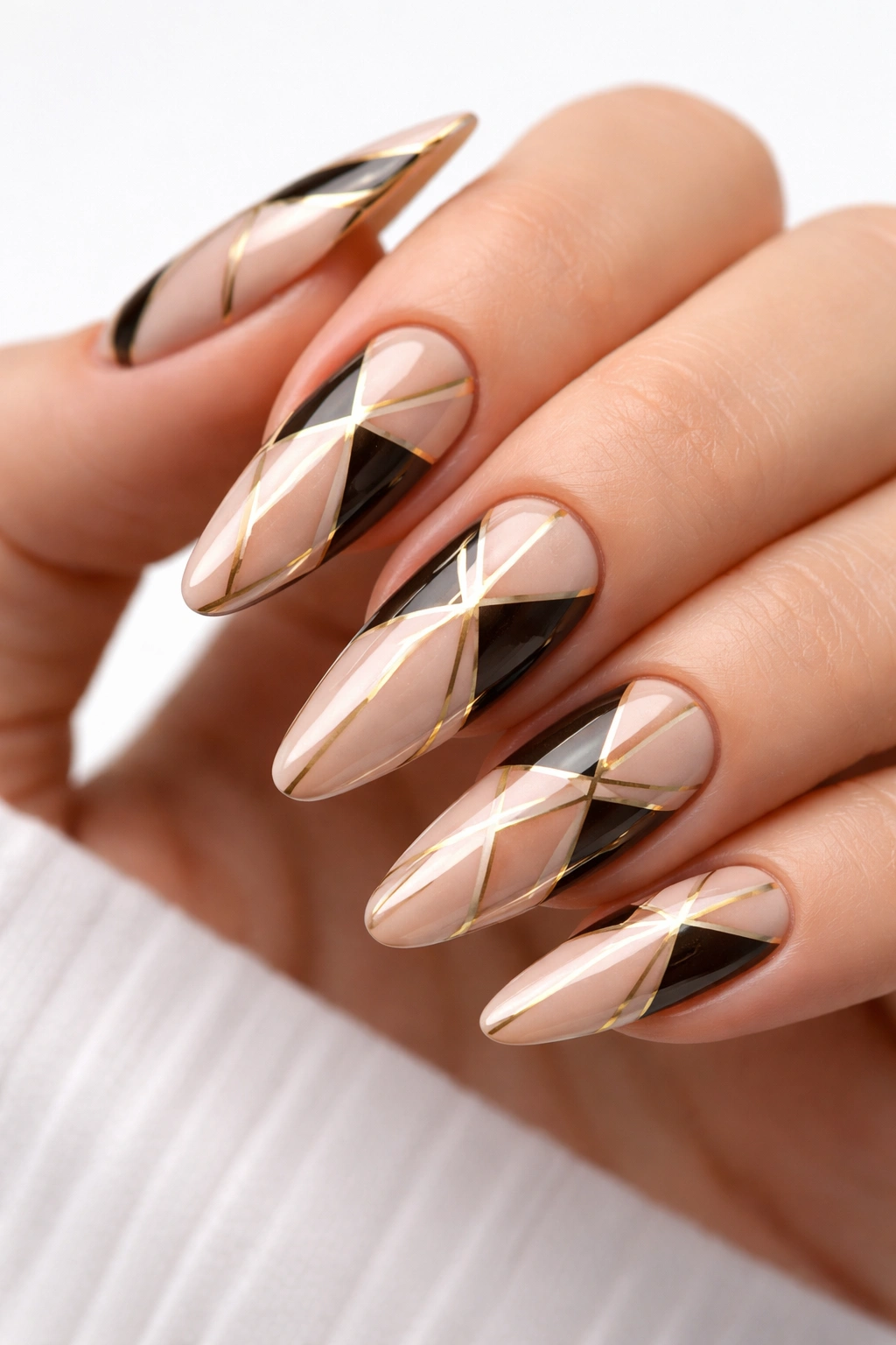 Close-up of long nails with geometric negative-space patterns and gold accents.