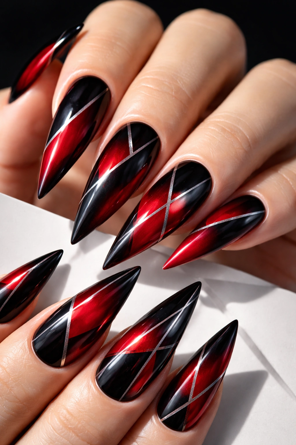 Close-up of geometric black and red ombre stiletto nails with crisp lines