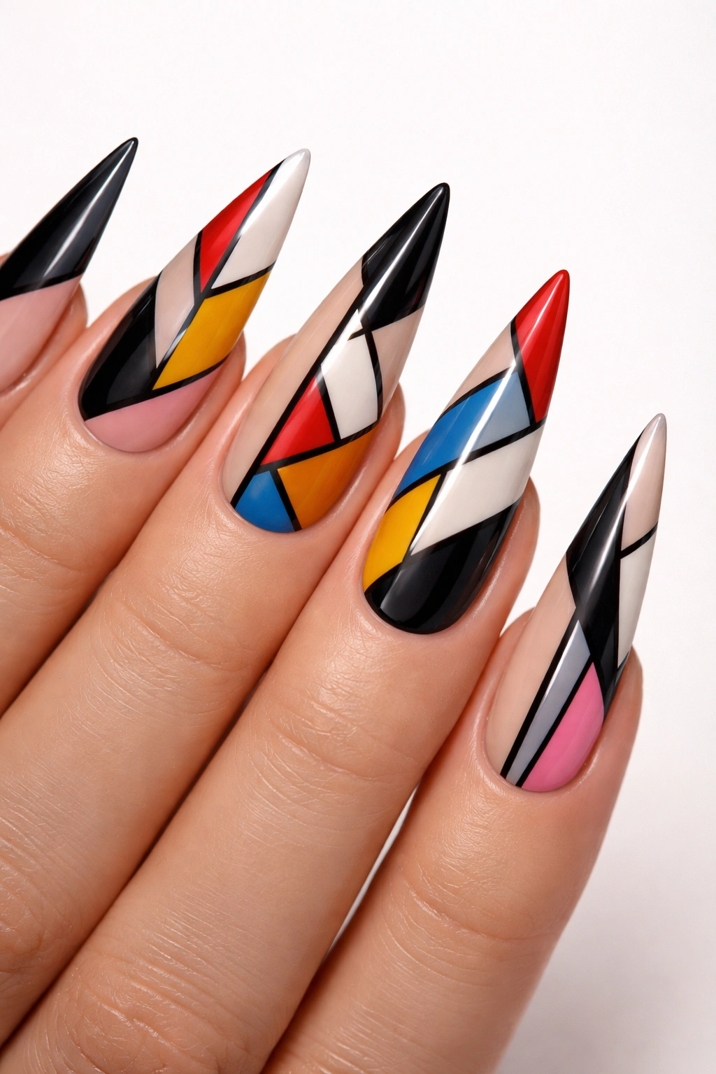 Close-up of stiletto nails with bold geometric patterns and color blocking