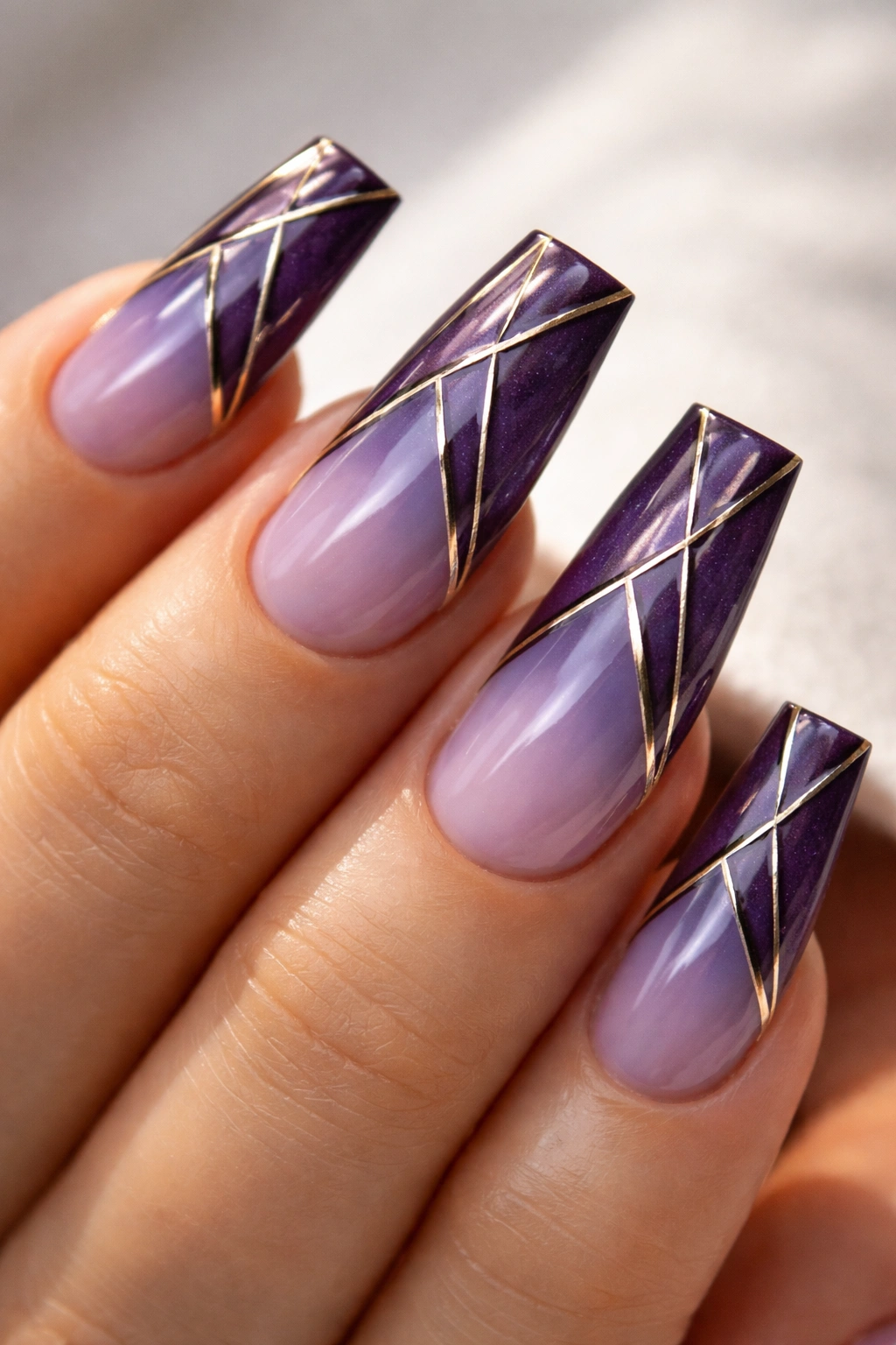 Close-up of geometric purple duck nails with metallic lines