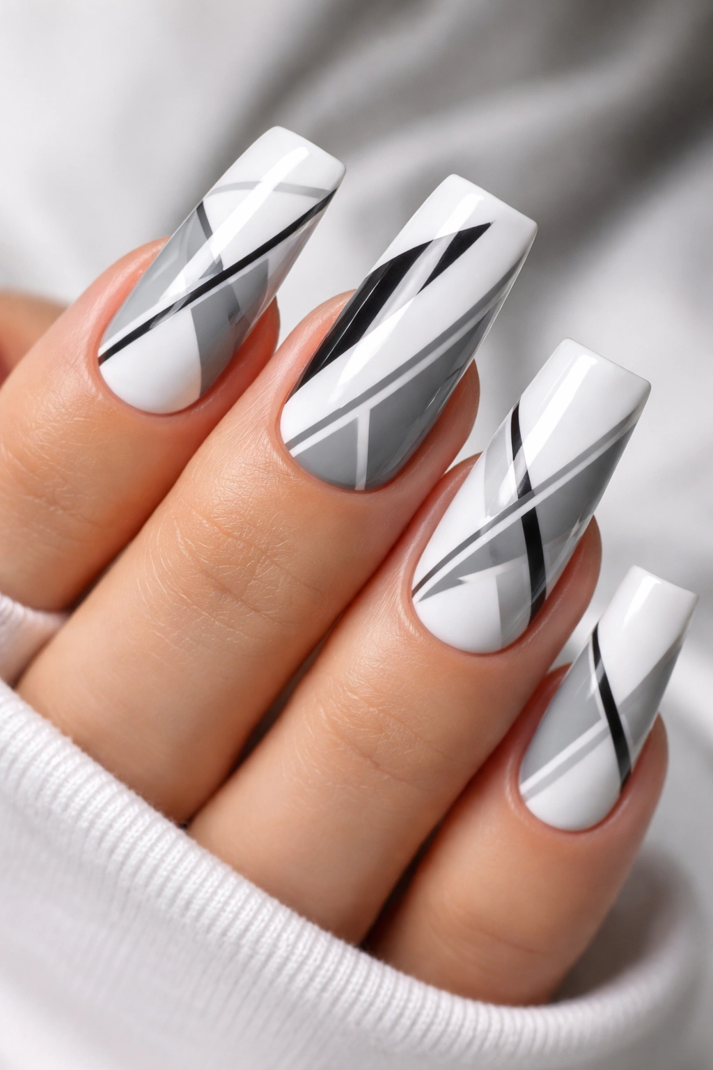 Close-up of geometric-patterned white duck nails