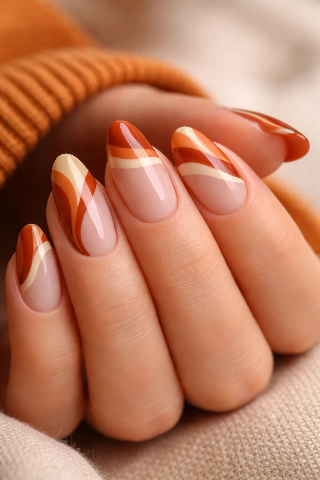 Short almond nails with warm ginger wavy French tips on pale base