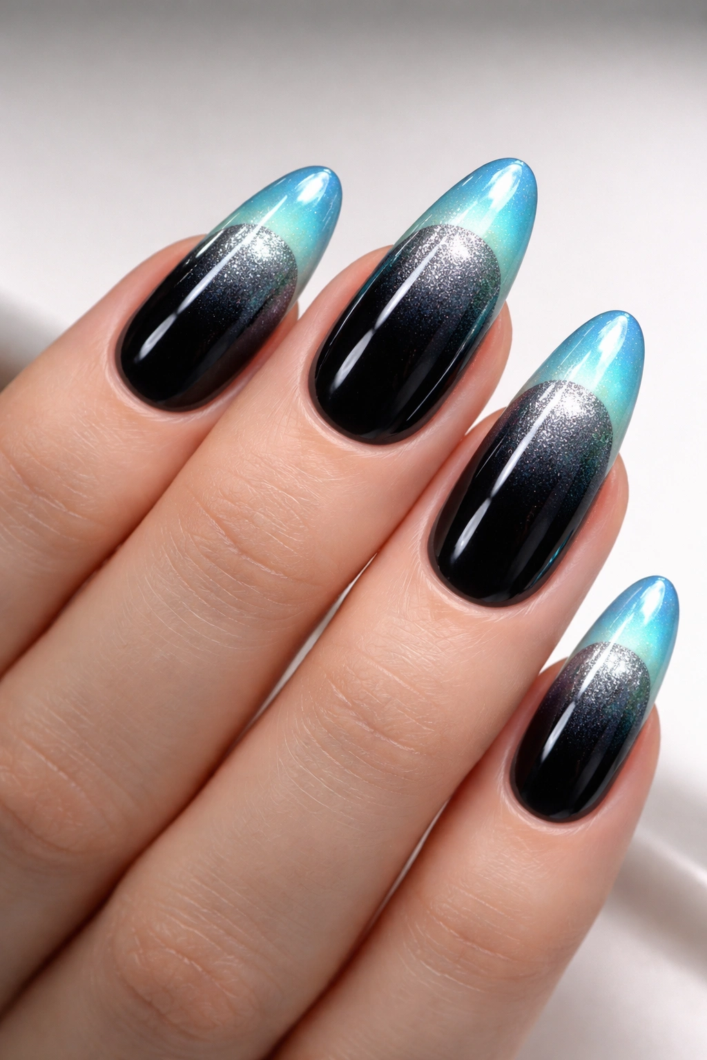 Close-up of glass velvet French tips on black base with silver shimmer and aqua tip