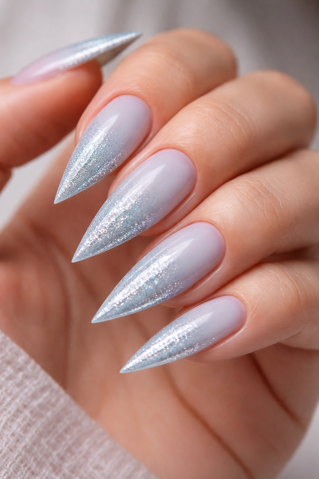 Baby blue nails with glitter gradient tip on stiletto nails.