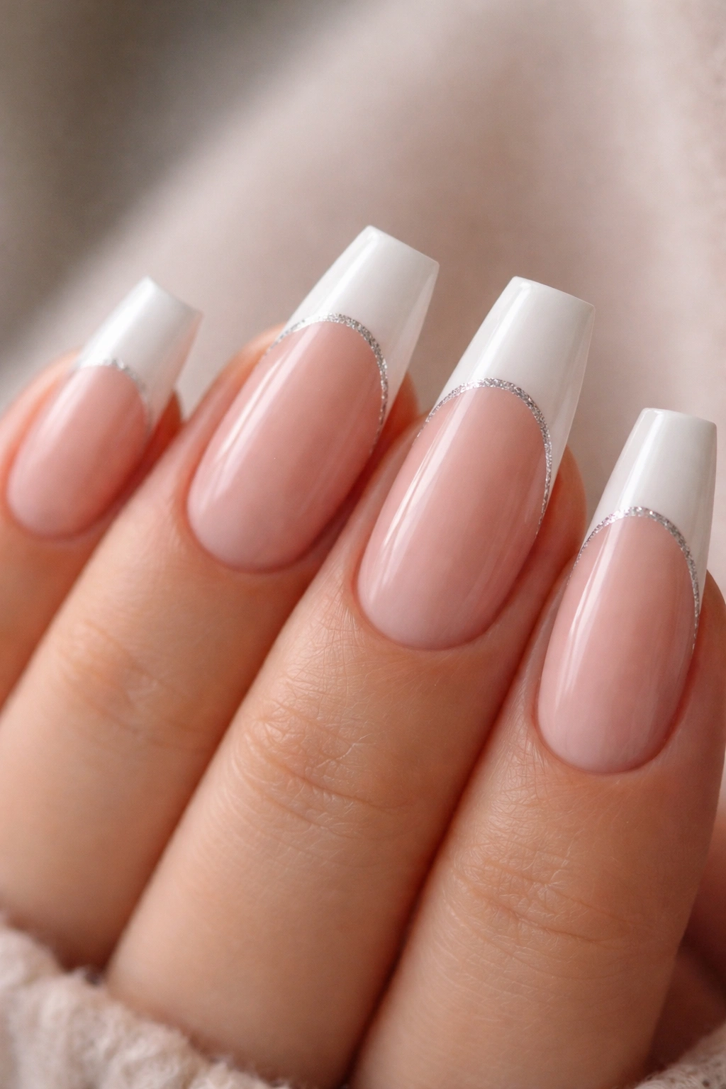 Close-up of glitter underline under white French tips on ballerina nails