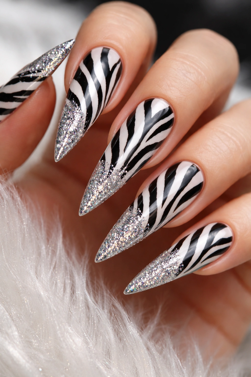 Stiletto nails with zebra stripes and a fine glitter gradient
