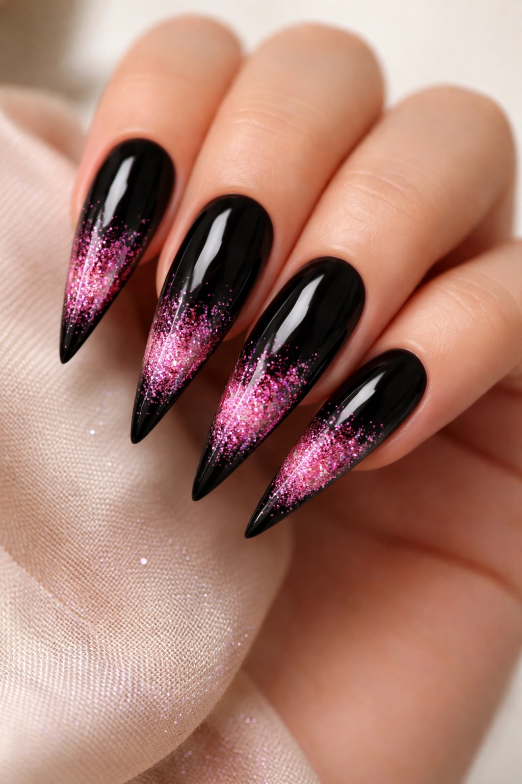 Black base nails with pink glitter gradient tips on a hand