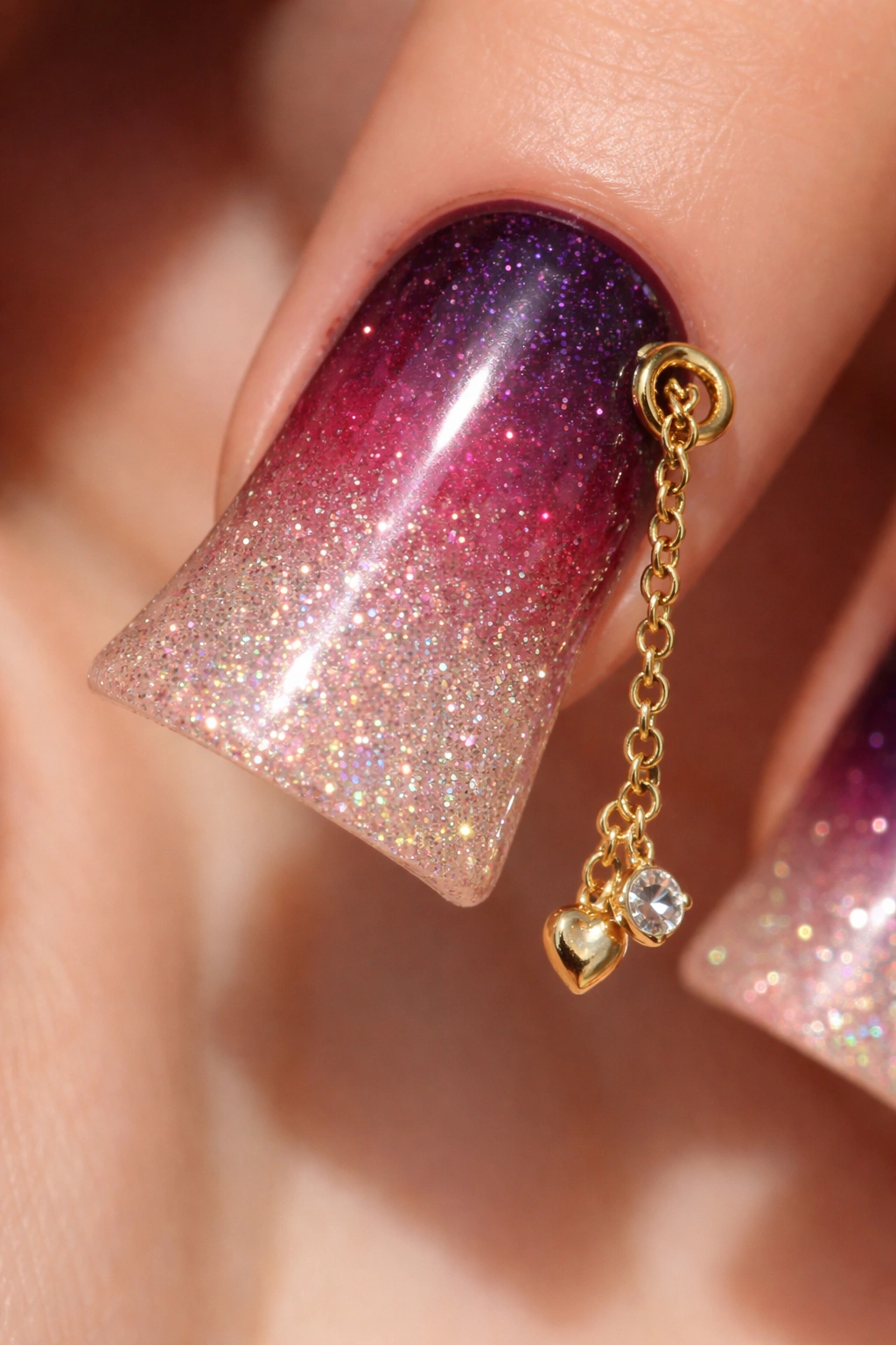 Duck nail with glitter ombre and gold chain charm.