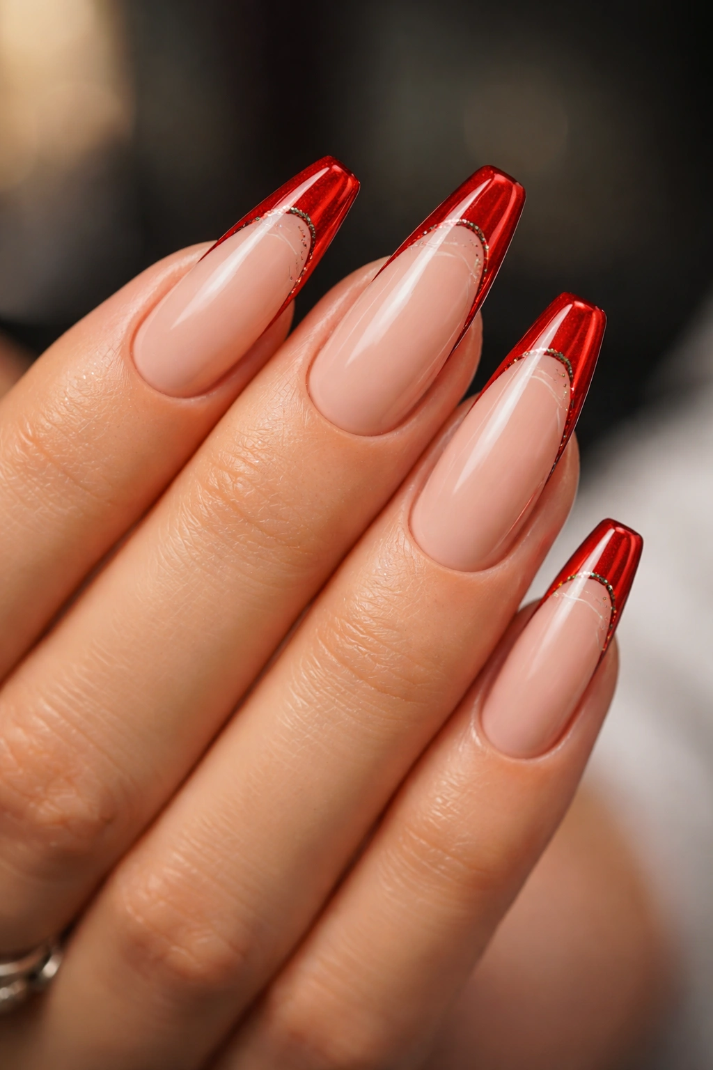 Fine glitter line tracing red French tip along the smile line on nude base