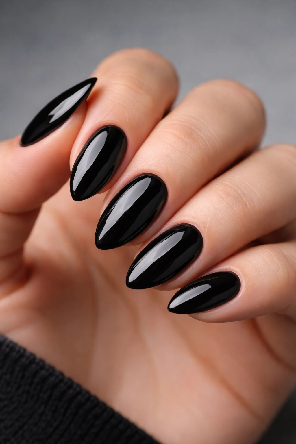 Close-up of short almond nails in glossy black with high shine