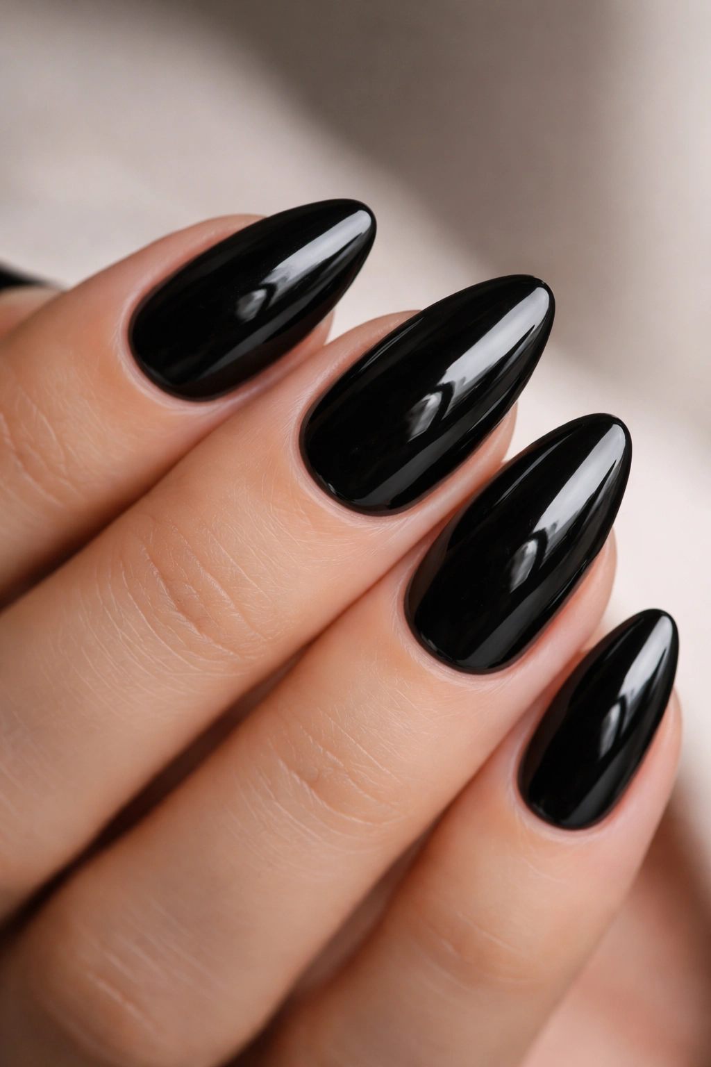 Close-up of short almond nails with high-shine glossy black polish