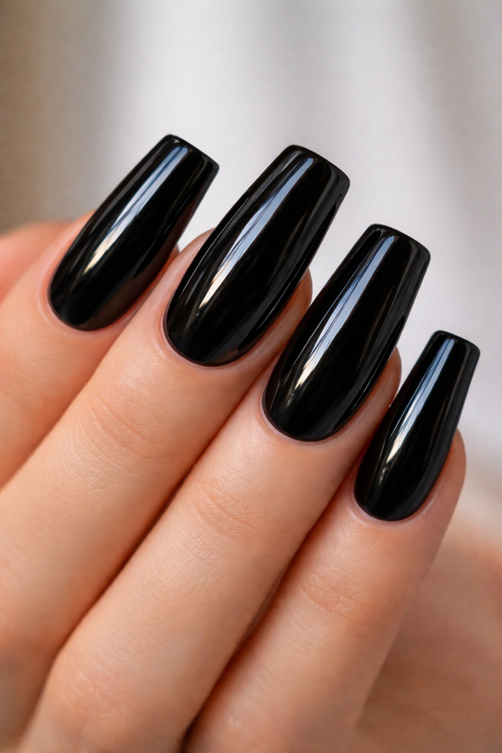 Close-up of classic glossy black duck nails with high-shine finish