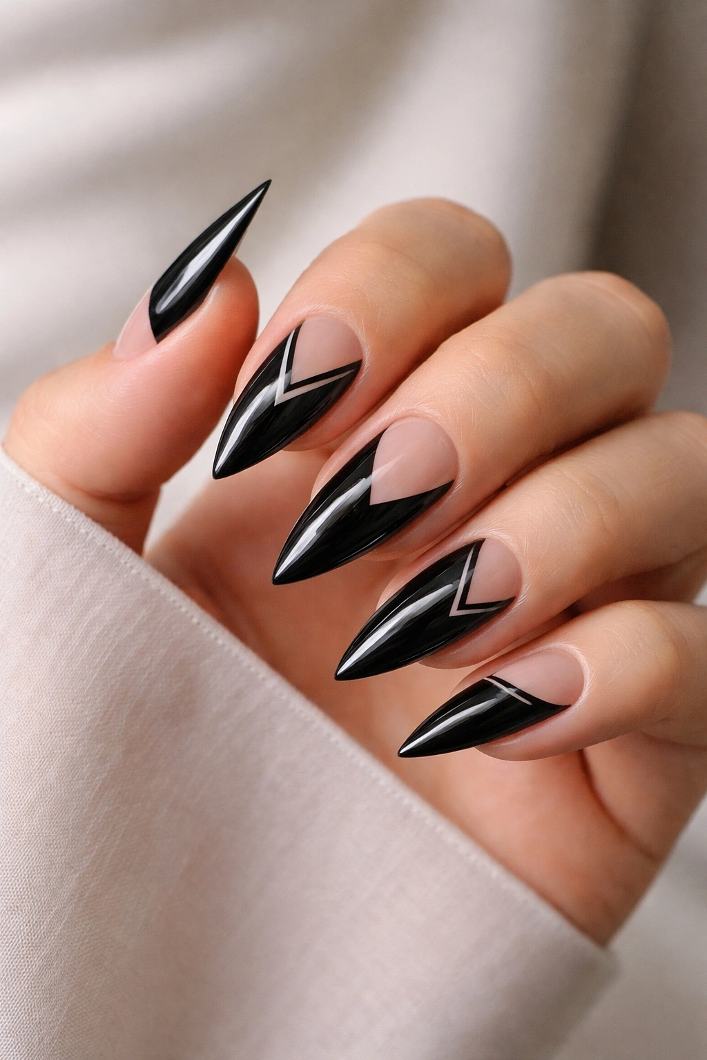 Glossy black stiletto nails with negative space geometric patterns