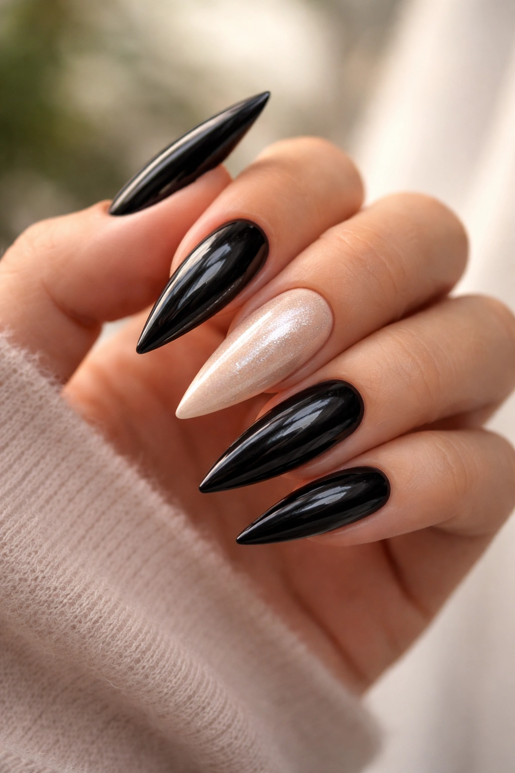 Close-up of glossy black nails with pearl accent nails