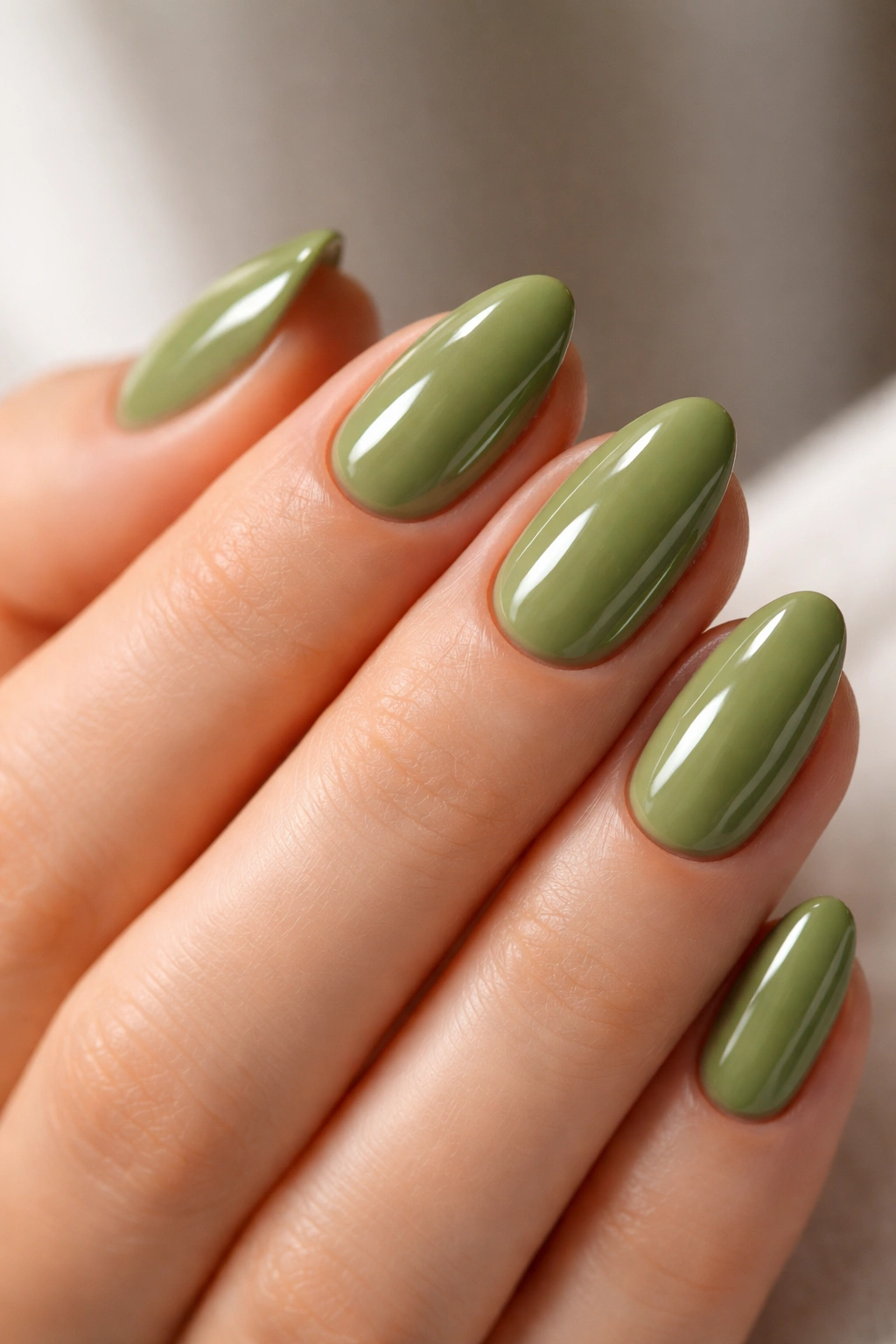 Close-up of glossy matcha green almond nails on short length