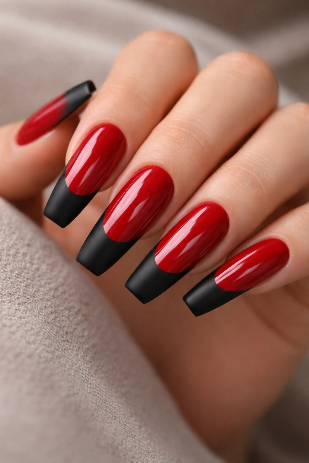 Close-up of nails with glossy red body and matte black tips