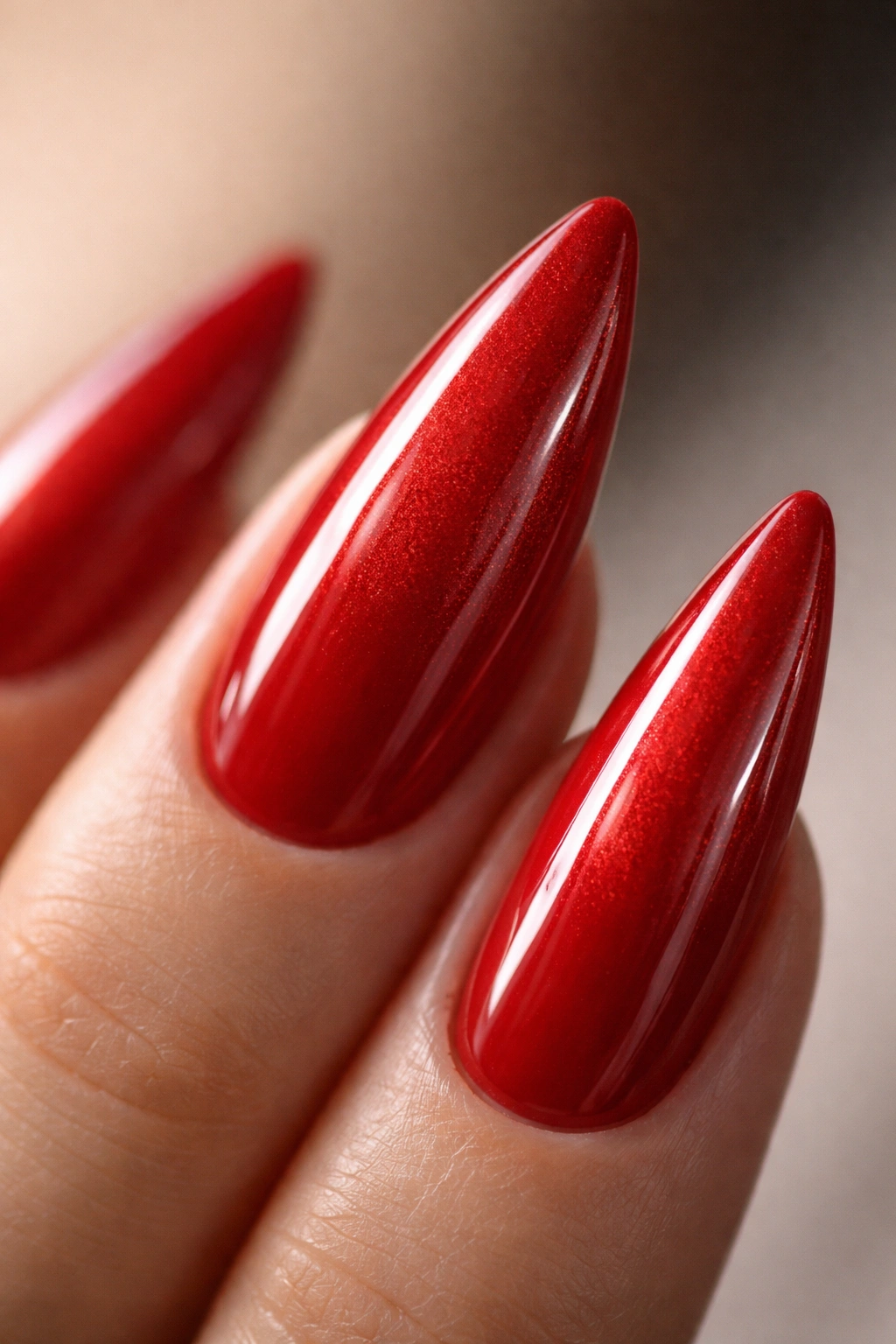 Glossy red stiletto nail with subtle shimmering topcoat