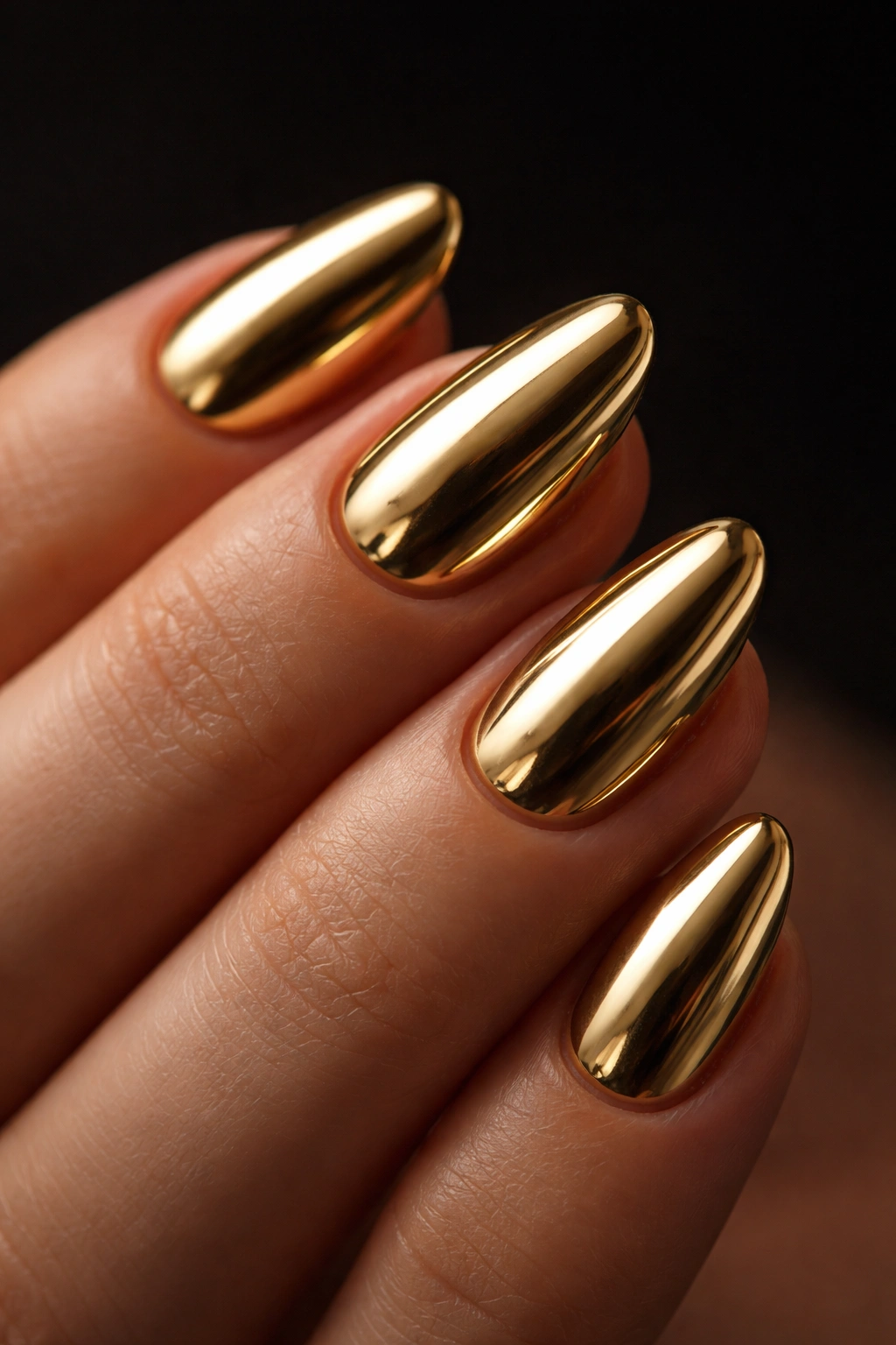 Close-up of a short almond nail with gold chrome and clean edges