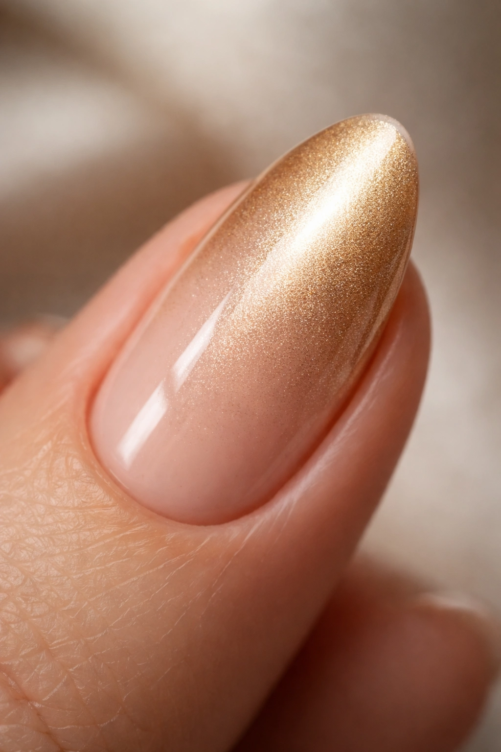 Almond nail with soft champagne gold finish close-up