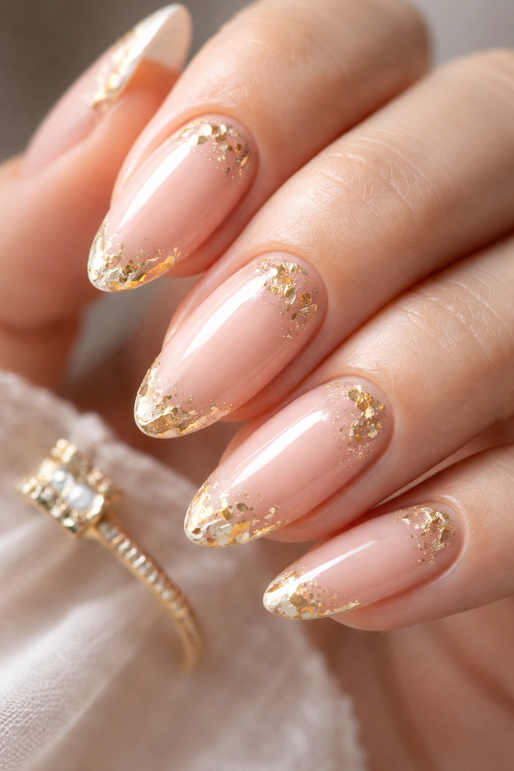 Nails with delicate gold foil accents on nude base
