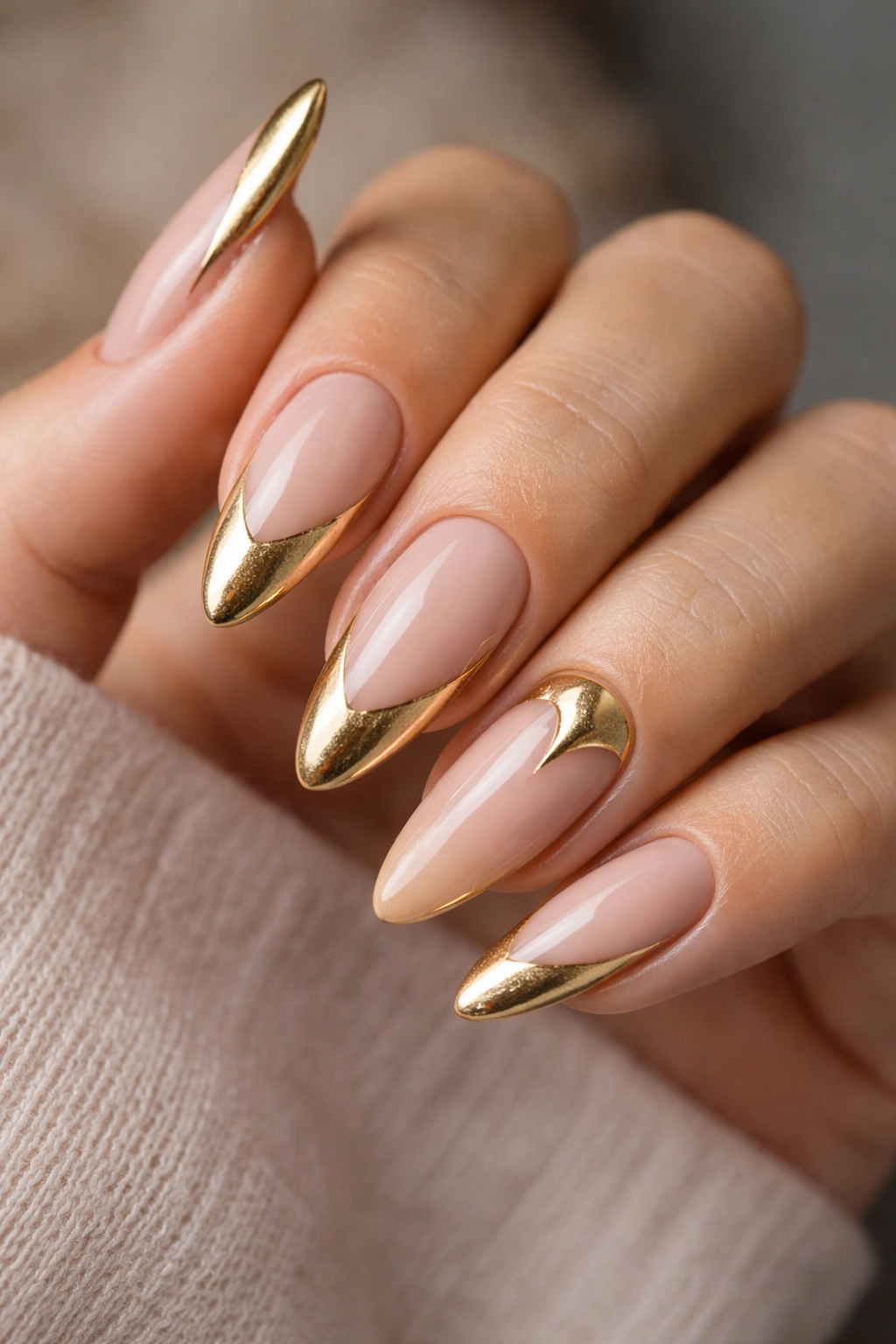 Almond nails with gold French tips featuring a twist format.