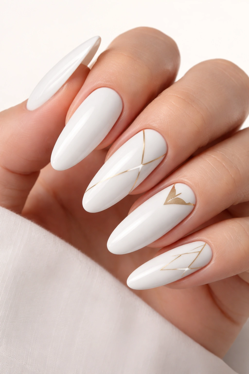 White oval nails with delicate gold geometric shapes