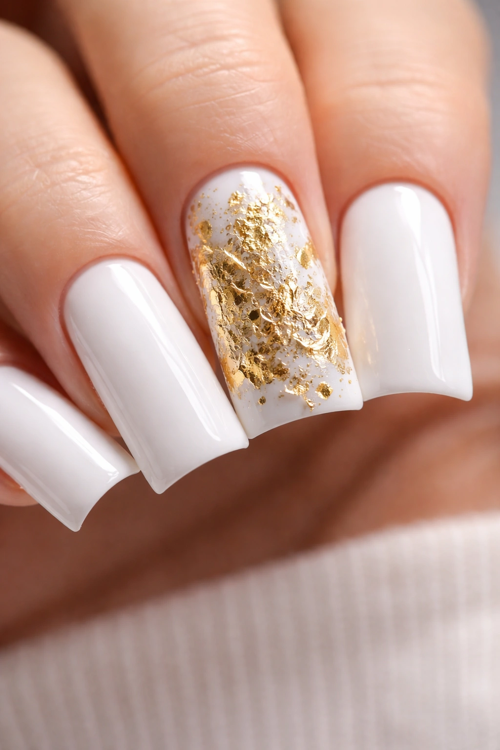 Nails with gold leaf accent on white base