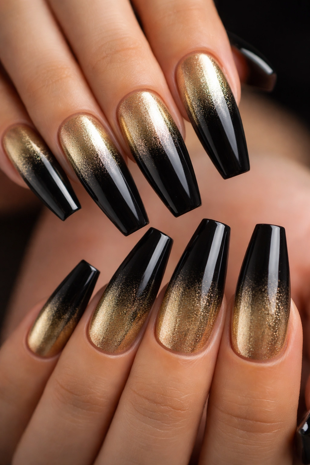 Coffin nails with black to gold ombre gradient and metallic shimmer