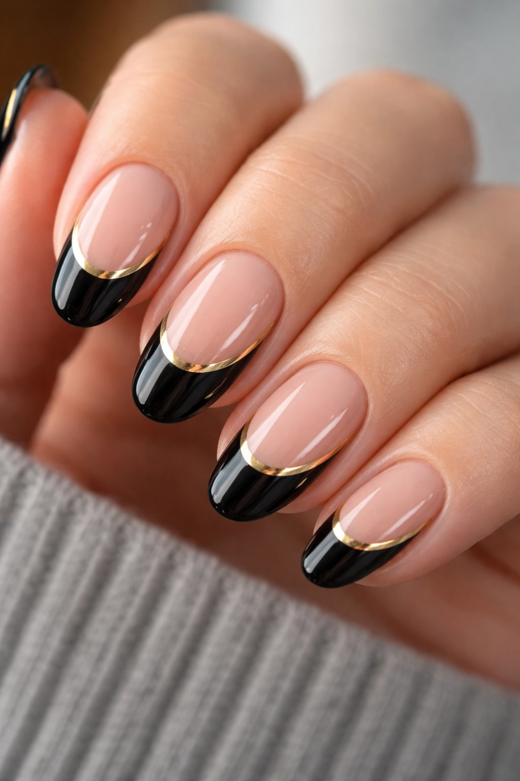 Gold stripe detailing on black French nails with a white tip.