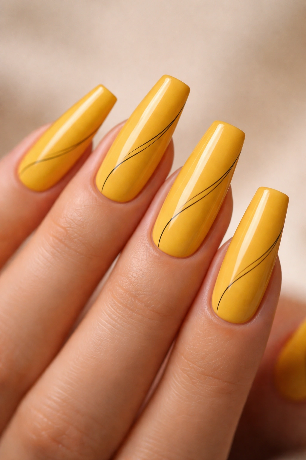 Close-up of coffin nails in golden yellow with minimalist line art