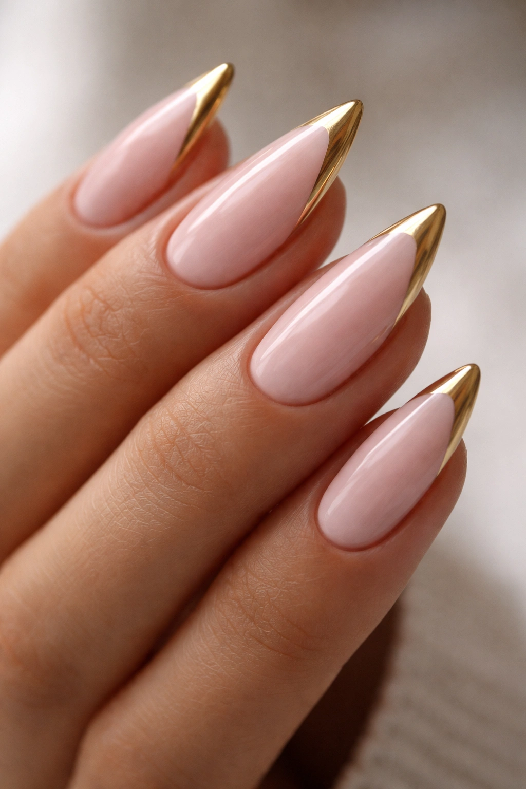 Almond nails with thin gold V-tip close-up