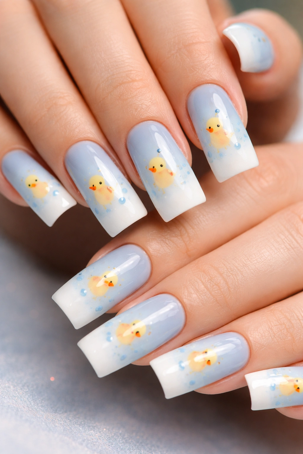 Nails with a blue-to-white gradient and simple duck silhouettes.