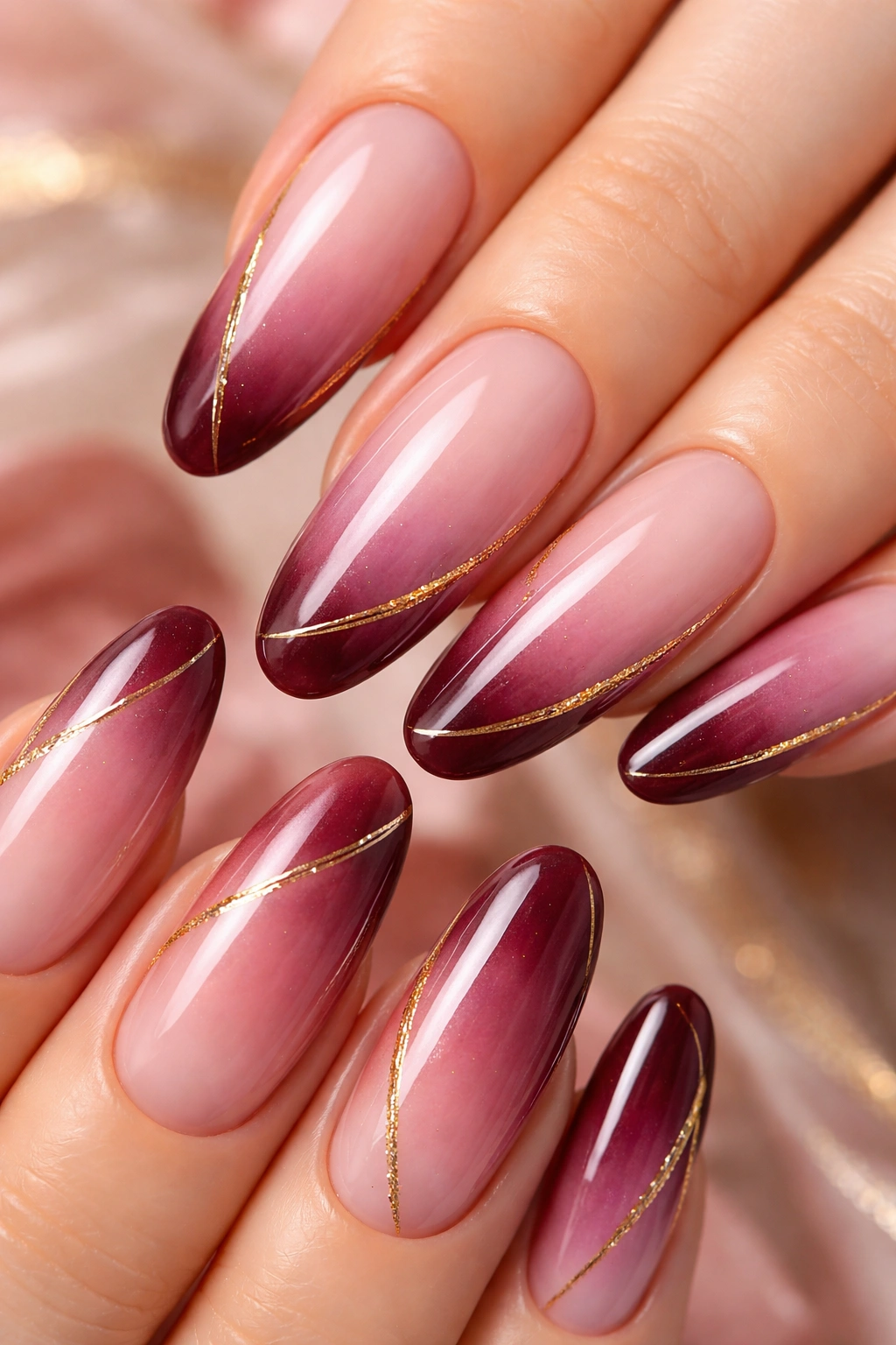 Nails gradient pink to burgundy with gold accents on long ovals