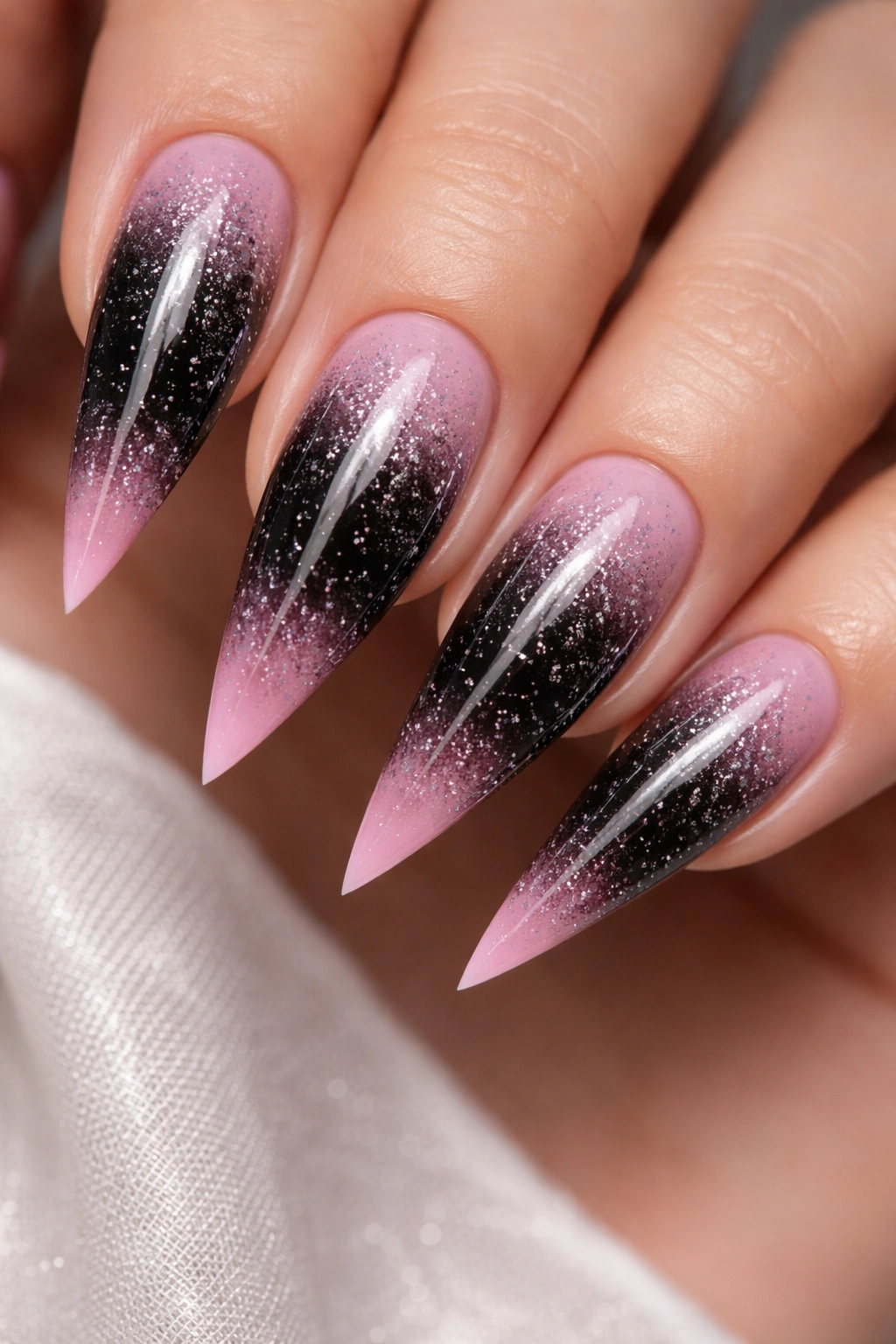 Stiletto nails with black to pink ombre and white speckle details
