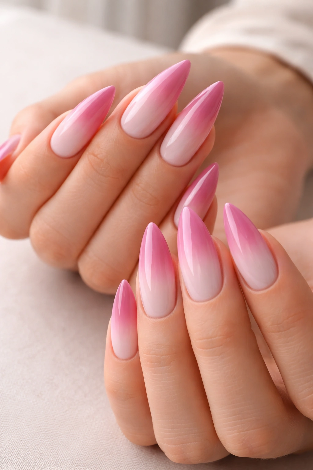 Close-up of medium-length stiletto nails with a seamless white-to-mauve pink gradient