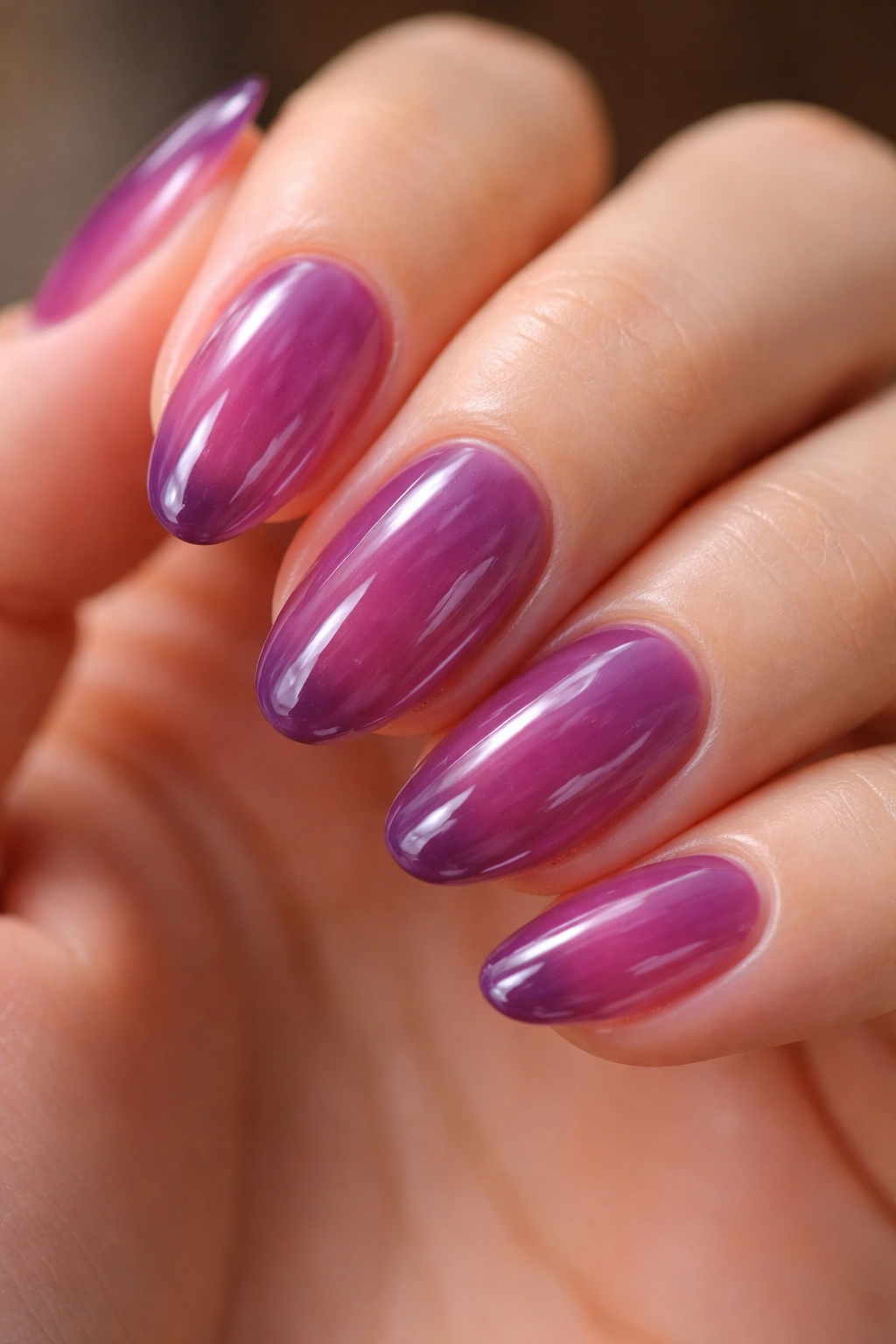 Close-up of short almond nails with translucent grape jelly polish