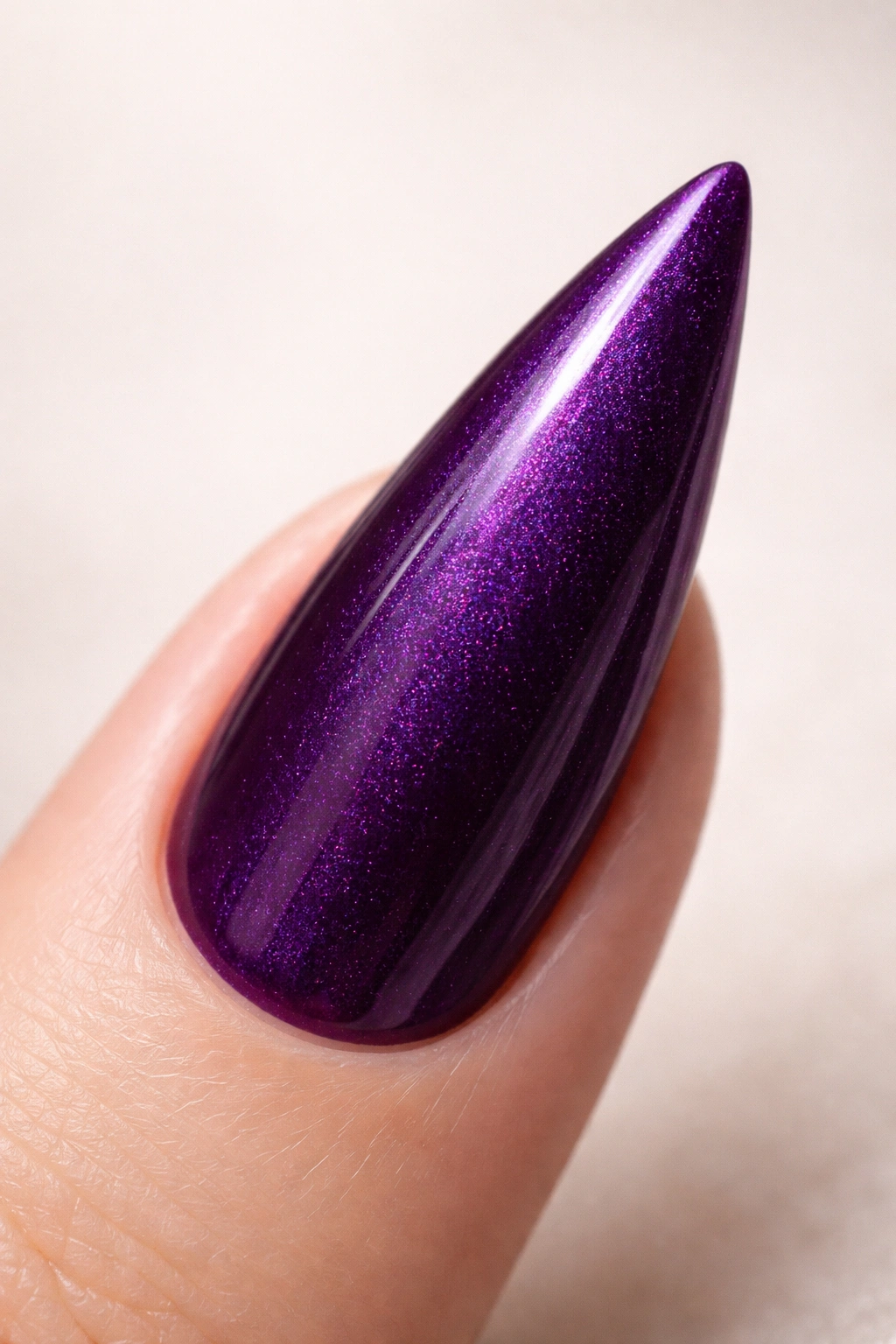 Close-up of grape purple stiletto nail with subtle shimmer