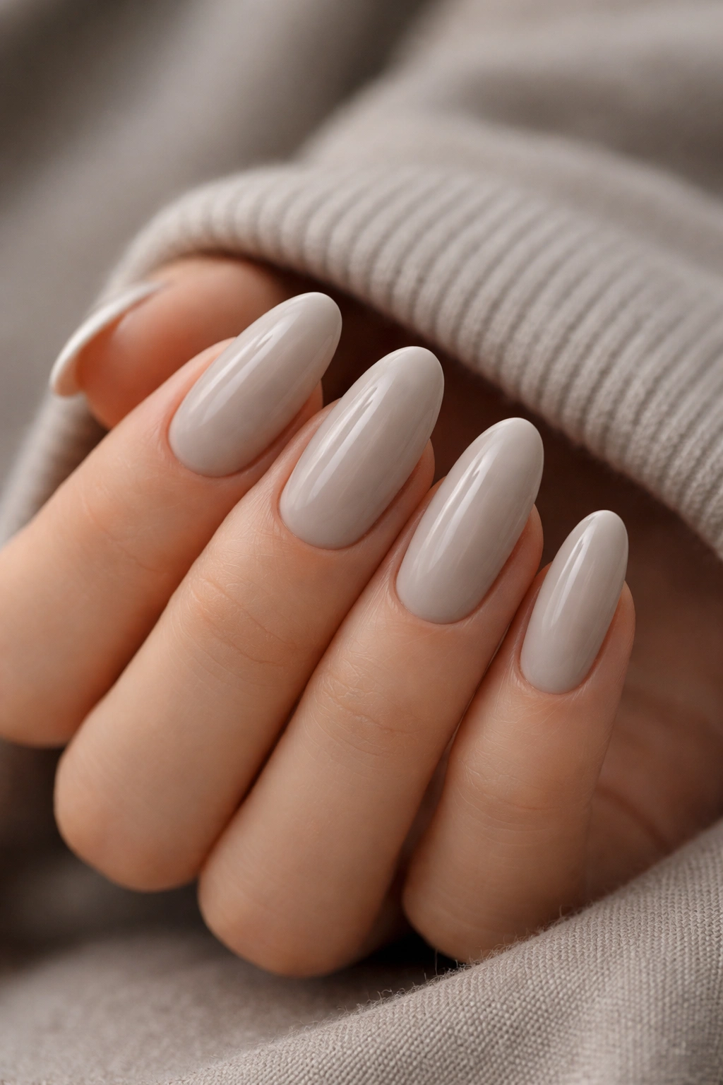 Close-up of long oval nails in soft gray-beige shade