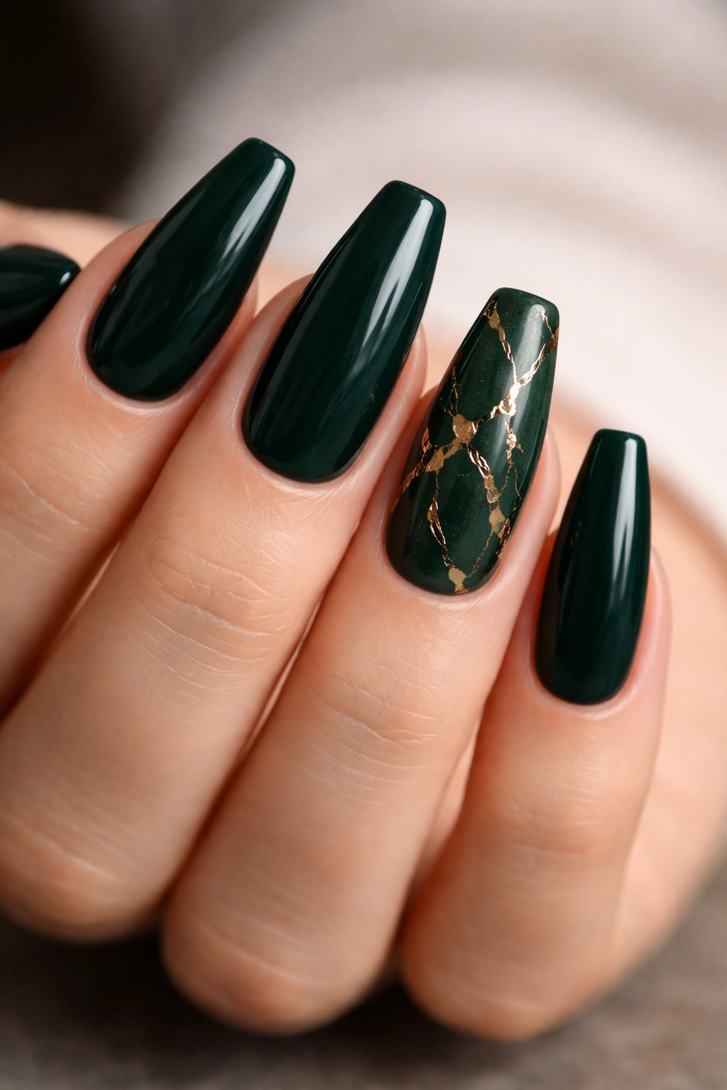 Dark green nails with cracked gold foil veins on selected nails.