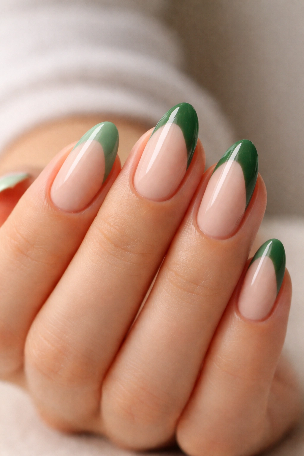 Close-up of short almond nails with dual-tone sage and forest green tips