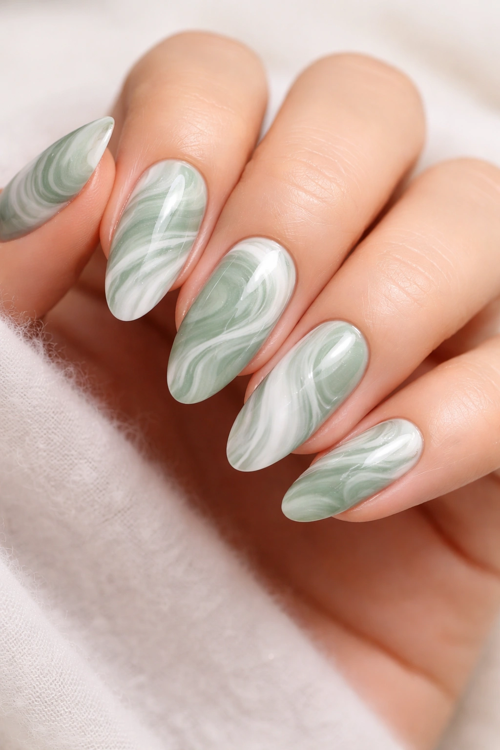 Close-up of green and white marble swirl nails with organic veining