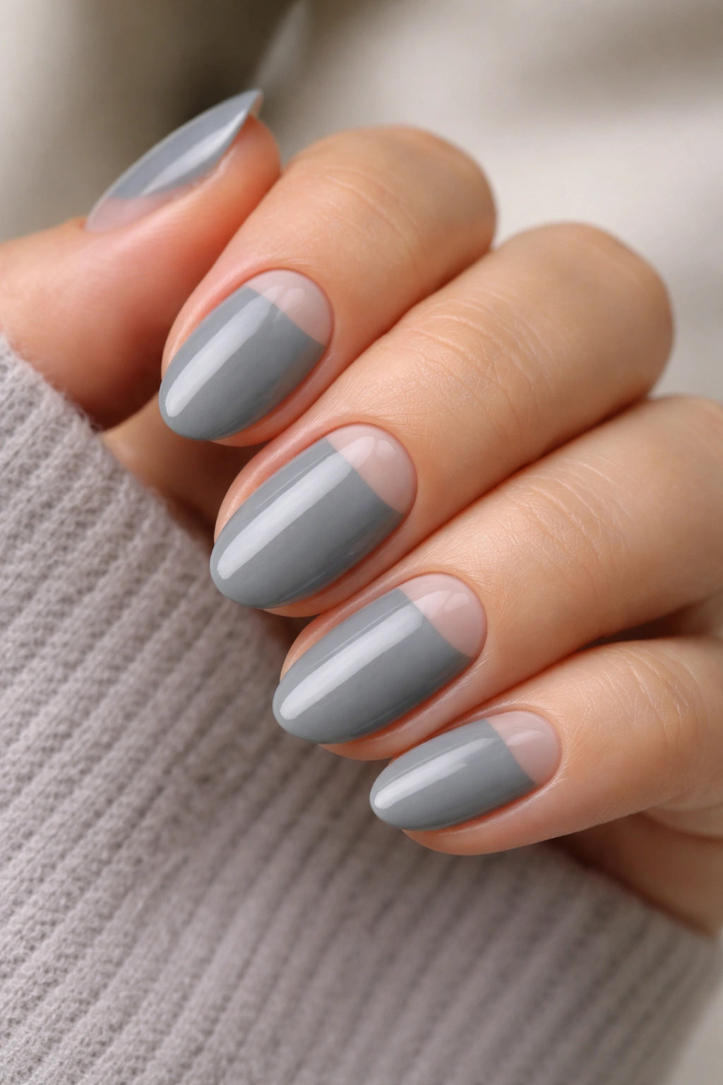 Short almond nails with grey polish and clear negative space crescent