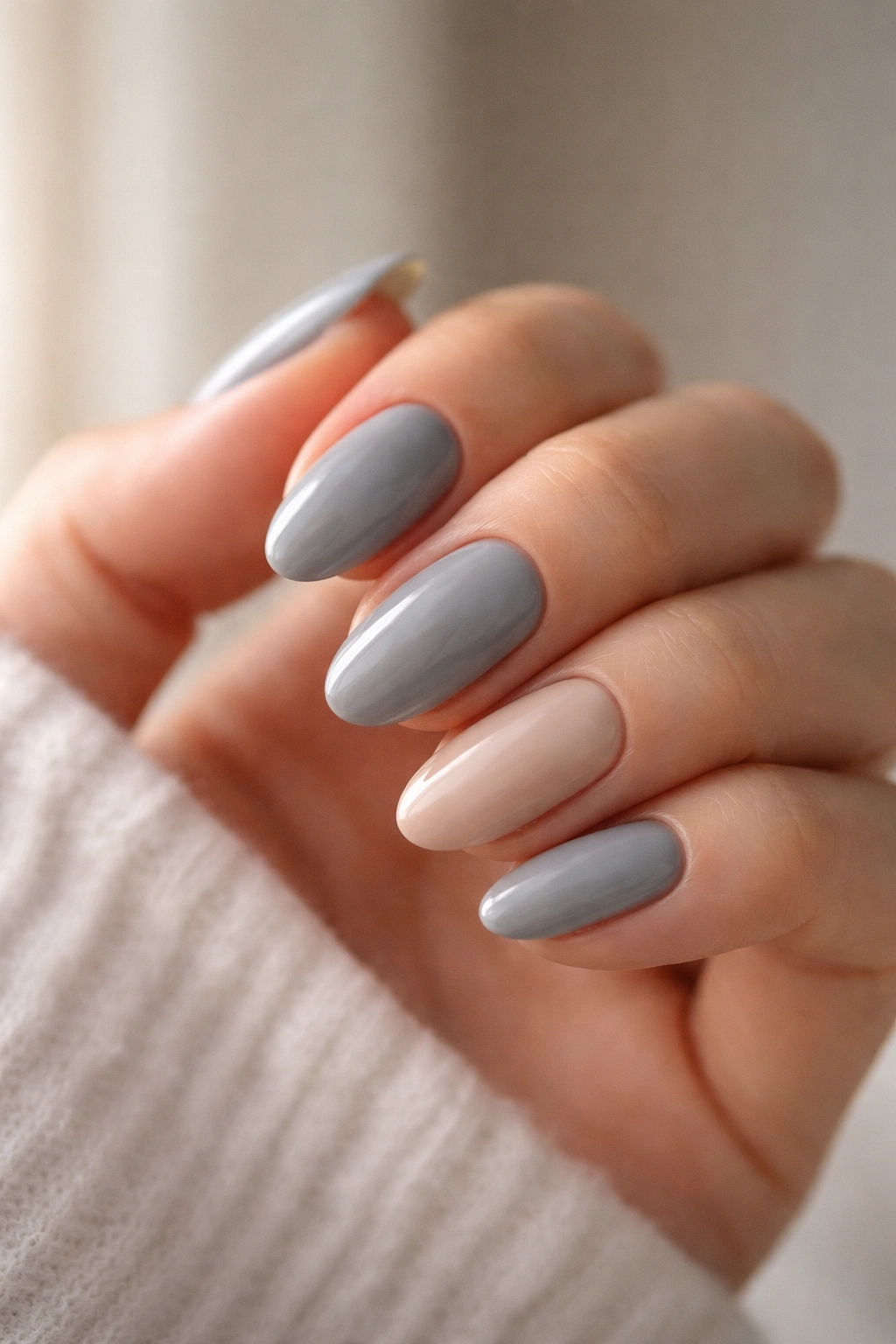 Close-up of short almond nails with a nude accent on the ring finger