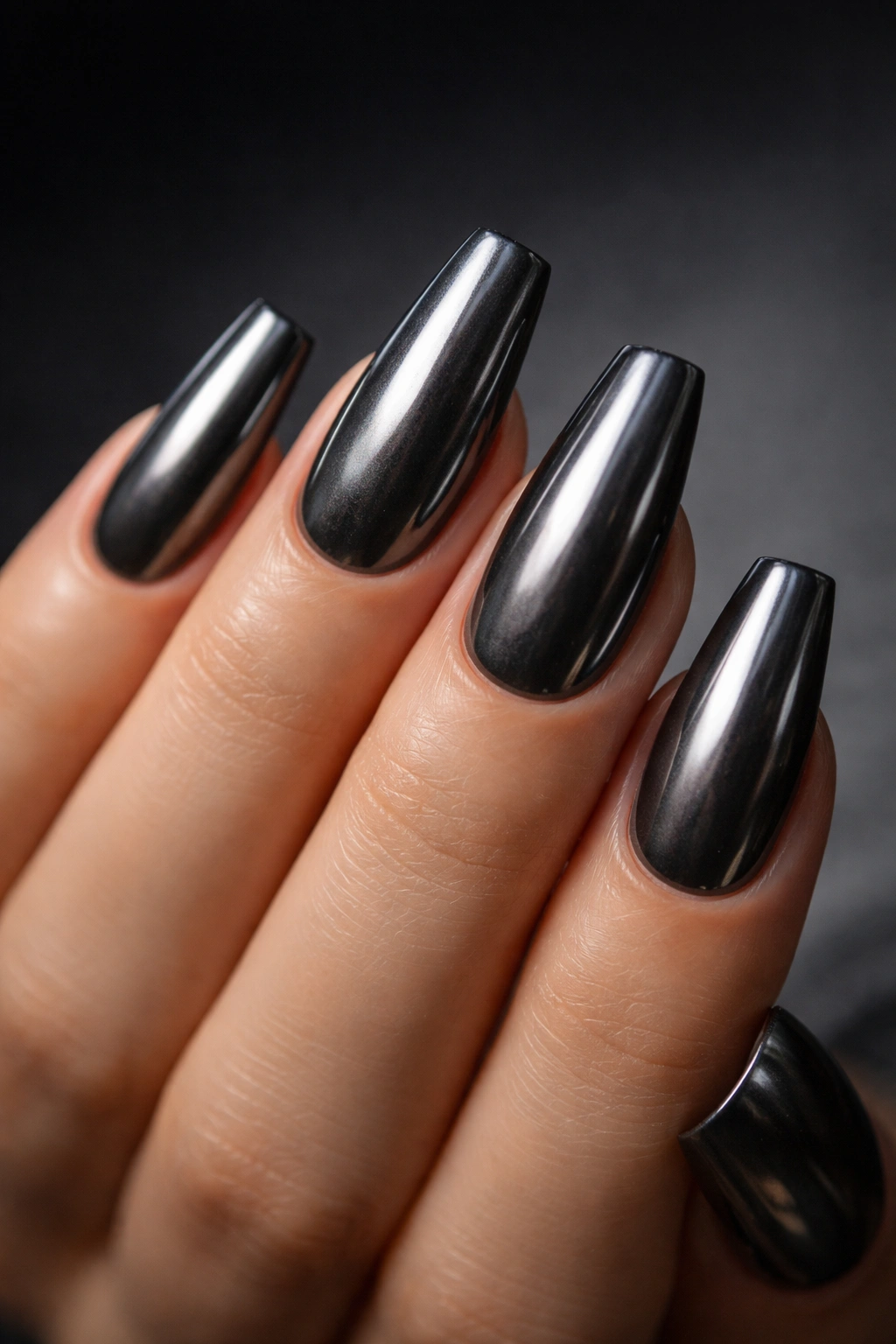 Close-up of gunmetal smoke chrome ballerina nails on charcoal base with moody lighting